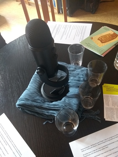 Zu sehen: Runder Tisch mit Mikrofon, Gläsern und Unterlagen, an dem das Interview aufgenommen wurde.